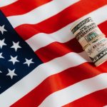 american-flag-with-rolled-dollar-bills